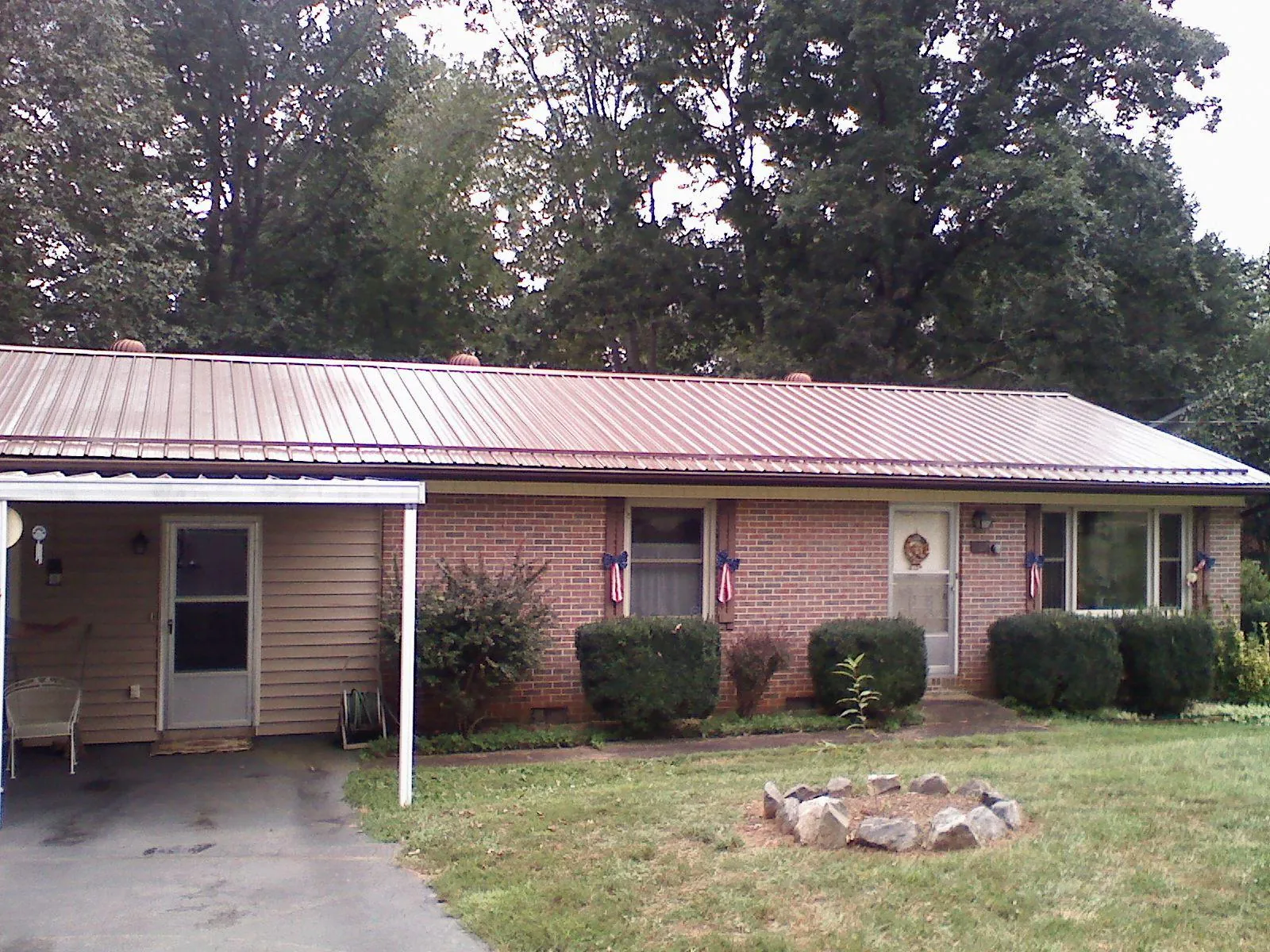 Bronze metal roof and carport on a brick ranch home — Roof Repair work by our crew in Agency