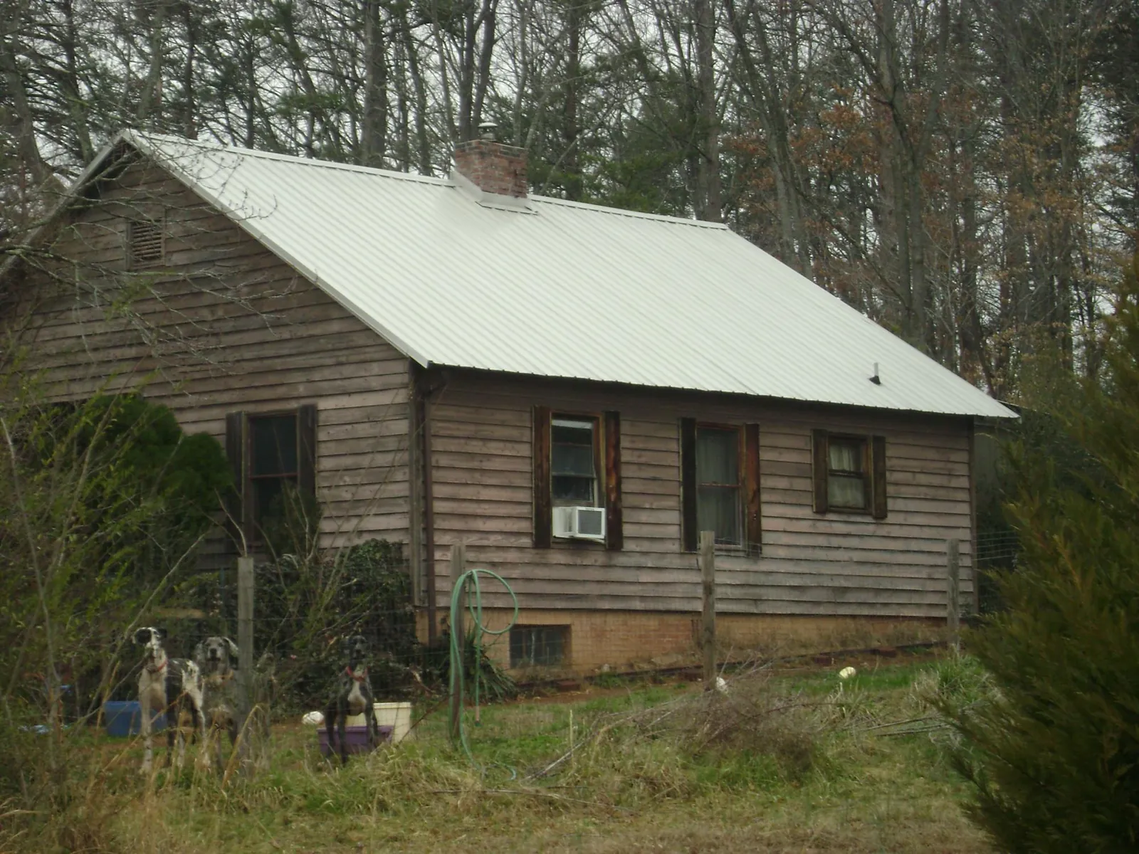 White metal roof on an old wood sided farmhouse, from a Metal Roof Installation job in Agency